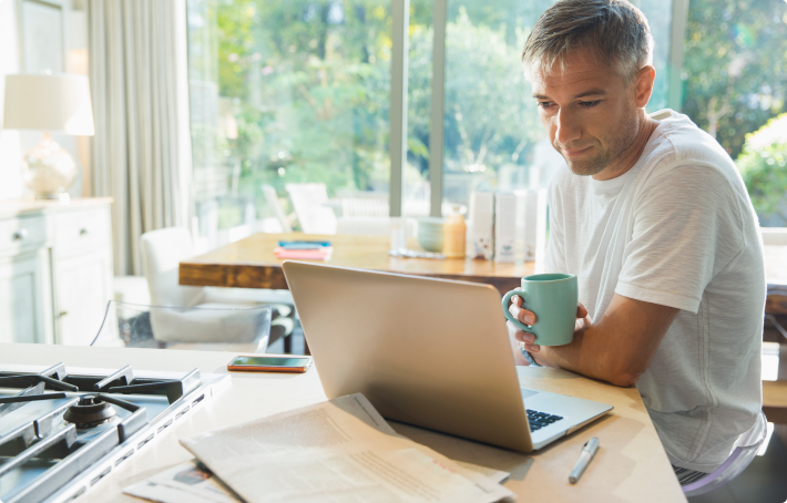 Middle aged male reviews annuity rates on laptop